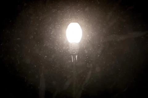 Street light shining through falling snow Stock Photos
