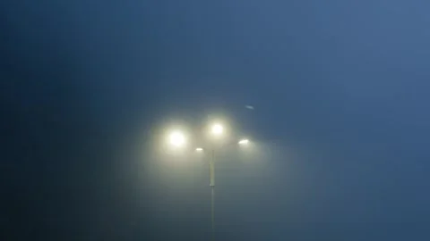 Street light shining through thick night fog Video stock 343925933