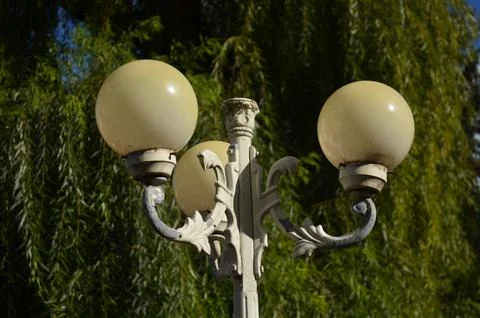 A street light with three bulbs is lit up. Stock Photos