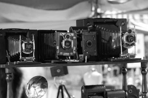 Street market shelf with antique cameras, black and white photo Stock Photos