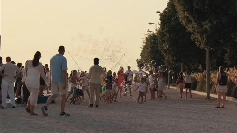 Street performer creating giant soap bubbles on waterfront promenade in Zadar Stock Footage 340628036