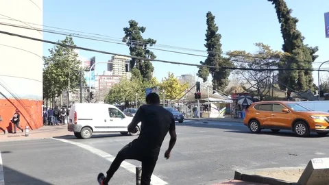 Street performer makes a basic stunt atop a pillar on the sidewalk Stock Footage 95957401