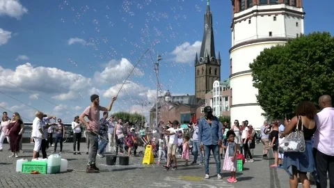 Street performer making bubbles  at Dusseldorf historic center Stock Footage 84960981