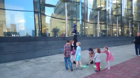 Street performer making large soap bubbles for children to chase Stock Footage 50080165