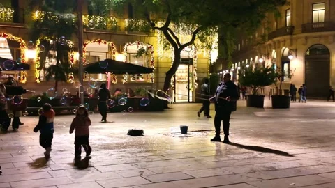 Street Performer Making Soap Bubbles for Children in Barcelona at Night Vídeo Stock 340603449