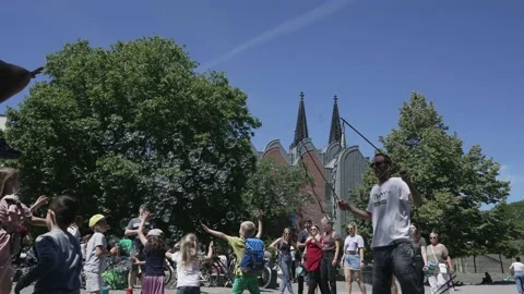 Street performer men making giant soap bubbles on an early summer afternoon ente Stock Footage 234313455