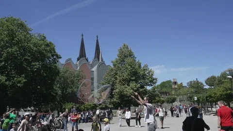 Street performer men making giant soap bubbles on an early summer afternoon ente Stock Footage 246697597