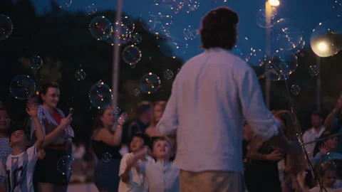 Street Performer Surrounded by Floating Soap Bubbles at Night Stock Footage 340424273