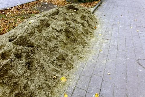 Street Repair Work Involves Sand Pile on the Roadside Near Sidewalk in Urba.. Stock Photos