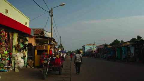 Street with shops both sides and towed motorcycle foreground, Ouesso Stock Footage 338167766