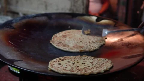 Street-side Magic Crafting Aaloo Paratha Delights in the Heart of Delhi Stock Footage 254807404