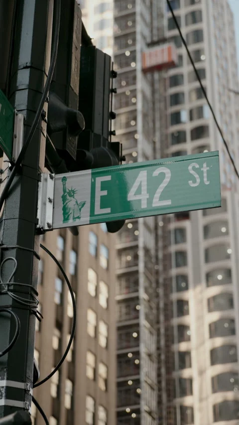 Street Sign Indicating E 42nd Street Set Against a Lively Urban Cityscape 스톡 동영상 292209769