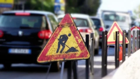 Street sign of work in progress and traffic behind 動画素材 79497188
