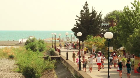 Street of a small resort town near the sea filled with strolling tourists Stock Footage 65999853