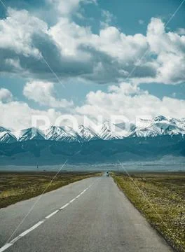 Street in steppe with Tian Shan mountains in background, Kazakhstan Central Asia Stock Photos