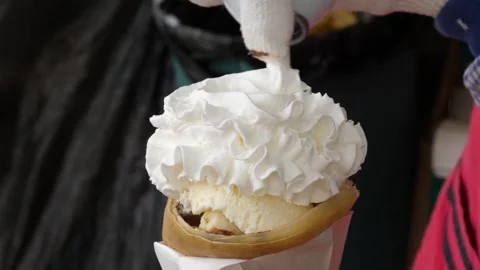 Street Vendor Adding Whipped Cream to Dessert Creep with Ice Cream 動画素材 343588304