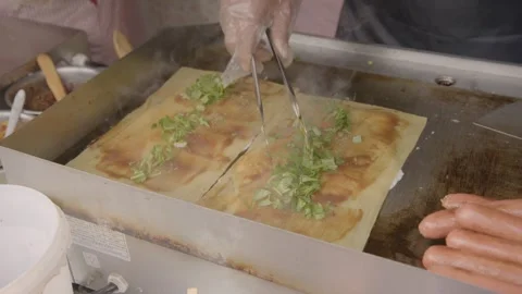 Street Vendor Cooking Savory Flatbreads with Sauce and Herbs on Griddle Stock Footage 345862030