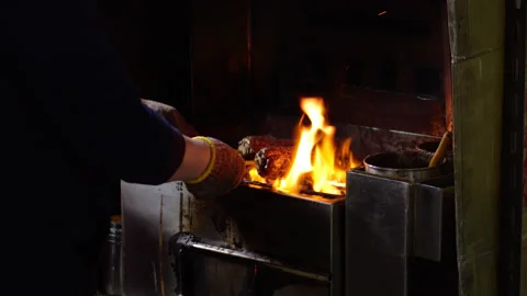 Street vendor grilling roasted corn on a stick over open fire, night market Vídeo Stock 341099660