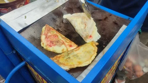 Street vendor prepares crispy folded egg snack Stock Footage 309212467