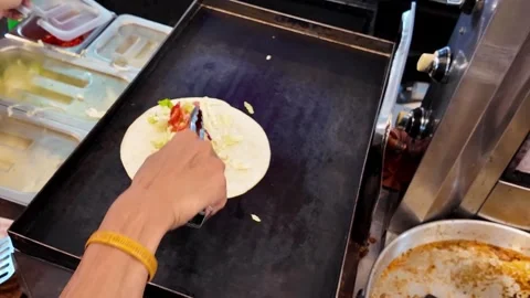 Street Vendor Preparing Shawarma Wrap Filling on Hot Griddle Stock Footage 335998682