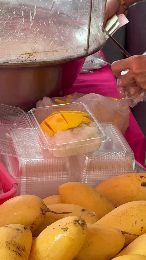 Street vendor slicing mango for mango sticky rice at local market in Thailand Stock Footage 336596932