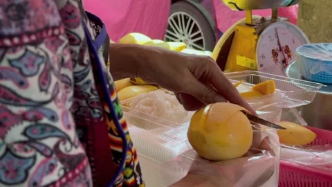Street vendor slicing mango for mango sticky rice at local market in Thailand Stock Footage 345908804