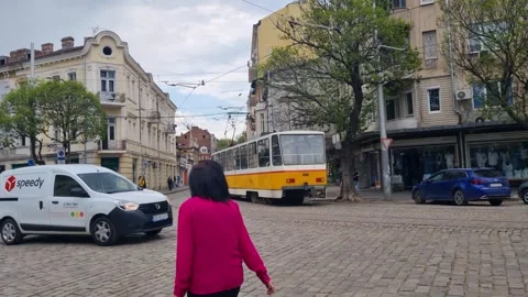 Street view in central Sofia, Bulgaria: a yellow tram moves along cobblestone Stock Footage 327537695
