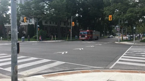 A street view of a large fire Paramedic truck entering High Park driving 스톡 동영상 98843807