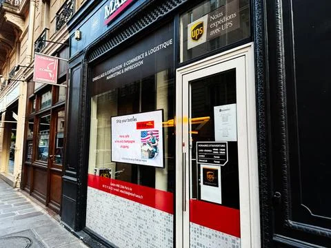 Street view of UPS store storefront and shipping service on a Paris street .. Stock Photos