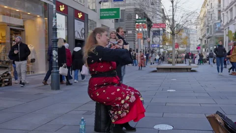 Street violin player musician playing for tourists on downtown pedestrian street Stock Footage 257487953