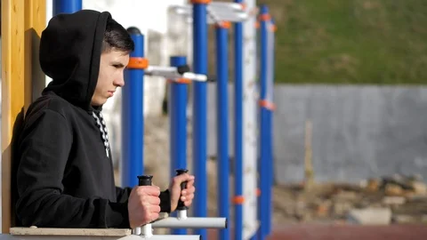 Street work out. a young guy in a hoodie makes a warm-up. fitness Stock Footage 125817434