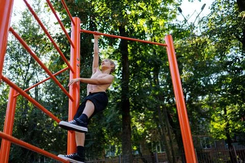 Street workout on a horizontal bar in the school park. Stock Photos