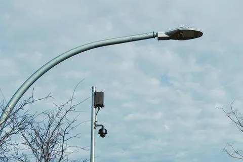 Streetlight with security camera under cloudy sky Stockfoto's
