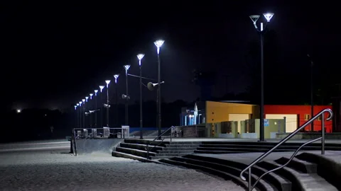 Streetlights on a beach at night as the wind blows sand Stock Footage 245213679
