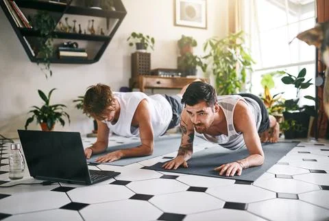 Strength comes from a solid foundation. two men using a laptop while going Stock Photos