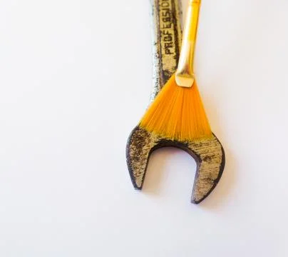 Strength, rustic and delicacy: simple wrench (mechanic's tool) and a yellow p Stock Photos