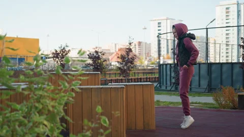 Strength Trainer Jumping On Wooden Bench In Urban Park Video stock 316655490