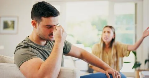 Stress, argument and man on sofa in home with conflict, breakup or cheating Stock Photos