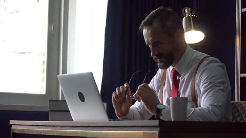Stress bearded business man using laptop computer take off  glasses and bit i Stock-Footage 158756830