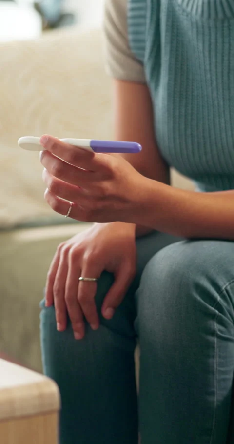 Stress, pregnancy test and hands of woman on sofa in home with regret, upset or Stock Footage 333176342