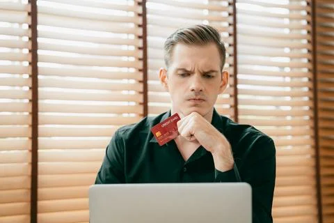 Stress young man sit at at table, pay credit card debt. Unveiling 스톡 사진