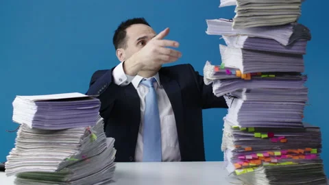 Stressed accountant manager takes stack of unfinished documents from large pile Stock Footage 134076651