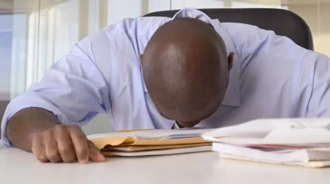 Stressed African American Businessman banging head on desk Stock Footage