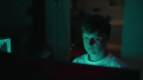 Stressed and tired programmer rubbing eyes while working on computer in dark Stock Footage 317829326