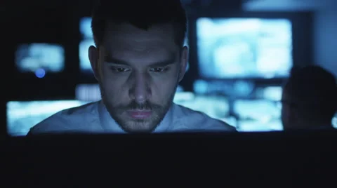 Stressed and tired security officer is working on a computer in a dark office 스톡 동영상 59609011