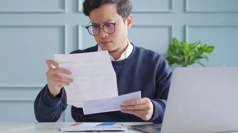 Stressed asian young man checking credit bills, concern about debt Stock Footage 147527289