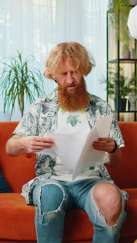 Stressed bearded man looking at unpaid bank debt loan doing paperwork planning Stock Footage 333459124