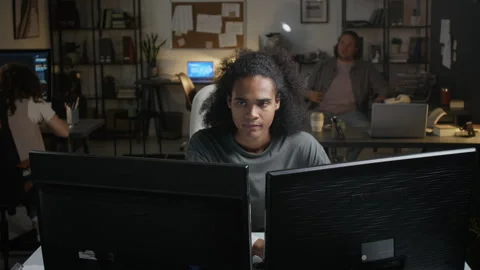 Stressed Black Man Working on Computers in Office at Night Stock Footage 348148783