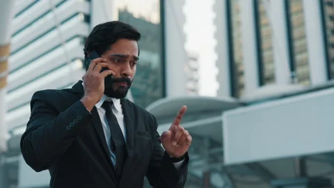 Stressed boss talking strictly by cellphone by skyscrapers Stock Footage 304221801