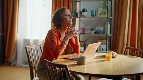 Stressed brunette closing laptop reading bad news in kitchen. Frustrated woman Stock Footage 333776426